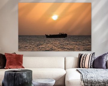 Tanzanian boat sails peacefully along the coast of Stone Town during sunset by Michiel Ton