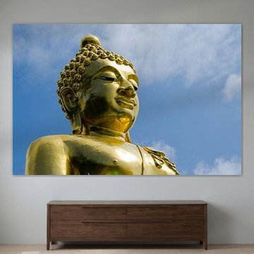 Gouden boeddha tekent af tegen blauwe lucht