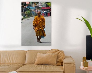Monnik in gewaad loopt over straat in Thailand
