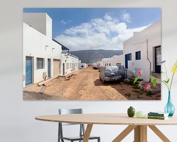 Lege straat met zand en witte huizen en een in plastic ingepakte auto tegen weersinvloeden in Caleta van Peter de Kievith Fotografie