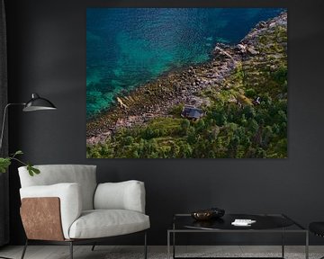 Klein rood huis aan de kust van de Lofoten, Noorwegen vanuit vogelperspectief