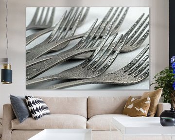 Abstracte artistieke foto van couvert, zijnde acht liggende vorken met waterdruppels tegen een witte