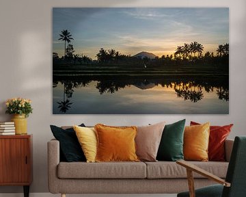 Reflection of a sunrise in a rice field in Bali by Ellis Peeters