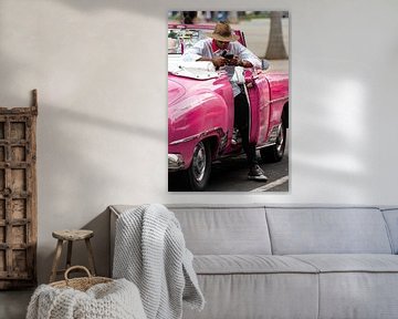 Man with mobile phone in pink vintage car in Havana by Dieter Walther