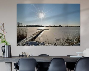 Strahlende Sonne an einem winterlichen Tag über dem gefrorenen Wasser der Wijde AA bei Woubrugge von Robin Verhoef