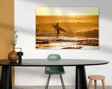 Surfer loopt branding in bij zonsondergang, Kalbarri, Australië