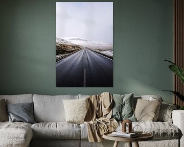 Een weg leidt door een besneeuwd landschap op de Faeröer van Moniek Kuipers