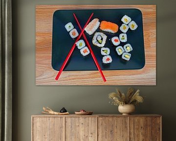 Sushi op zwart serveerbord geserveerd met rode eetstokjes