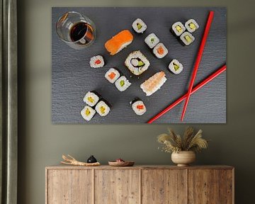 Sushi op zwart serveerbord geserveerd met rode eetstokjes