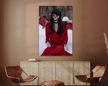 Duivel bruid skelet met rode jurk en duivel vleugels in de sneeuw