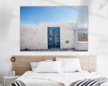 Witte muur en blauwe deur tegen de achtergrond van de blauwe zee op Santorini, Griekenland van WorldWidePhotoWeb