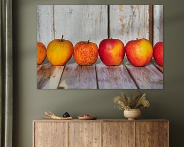 Appels liggen decoratief op een tafel in het zonlicht. van Michaela Bechinie