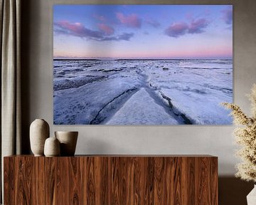 Ice covers the Wadden Sea in winter at the coast of Groningen during sunset. The setting sun gives a by Bas Meelker