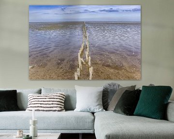 Holzpfähle auf dem Wattenmeer in Friesland von Marc Venema