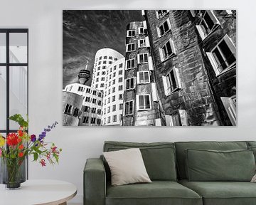 Les bâtiments de Gehry dans le port des médias à Düsseldorf avec la tour du Rhin en noir et blanc sur Dieter Walther