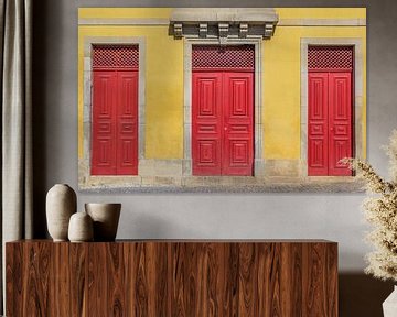 Rode deuren in een gele muur van een huis in Portugal