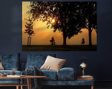 Cyclists and trees in silhouette in the morning at sunrise by Margriet Pflug