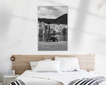 Couple on the waterfront overlooking the town of Cefalu, Sicily Italy in black and white by Manon Visser