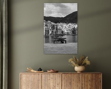 Koppel aan het water met uitzicht op de stad van Cefalu, Sicilië Italië in zwartwit van Manon Visser