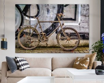 Oude vuile fiets op muur met graffiti van Dieter Walther