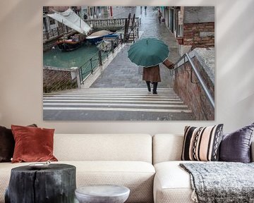 Dame met paraplu langs kanaal in centrum Venetie, Italie met veel regen