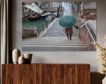 Dame met paraplu langs kanaal in centrum Venetie, Italie met veel regen
