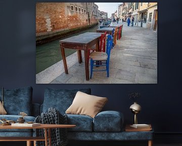 Tafeltjes met stoelen aan kanaal met boten in oude centrum Venetie, Italie