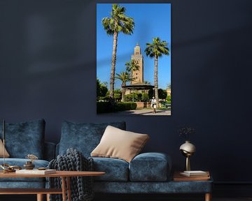 Pastry seller in park with palm trees in front of minaret Koutoubia mosque in Marrakech Morocco by Dieter Walther