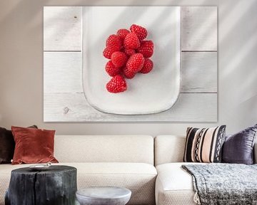 Raspberries on a plate on a wooden base. by Ans van Heck