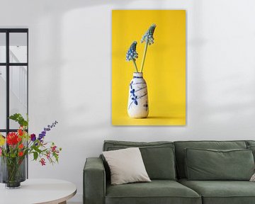 Klein chinees antiek vaasje met twee blauwe druifjes op gele achtergrond. van Marjolein Hameleers