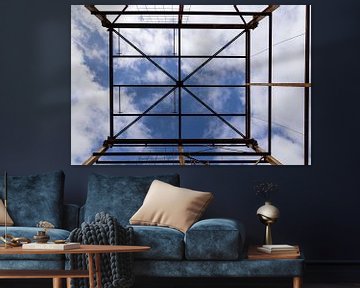 Urbex symmetrie- verroeste metalen constructie tegen een blauwe lucht met wolken van Photo Henk van Dijk
