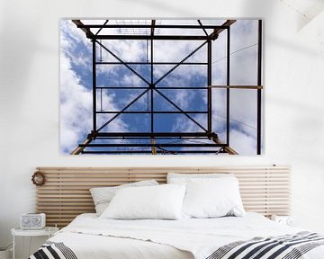 Urbex Symmetrie - verrostete Metallkonstruktion vor einem blauen Himmel mit Wolken