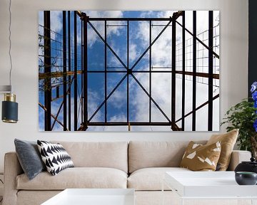 Urbex symmetrie - verroeste metalen constructie tegen een blauwe lucht met wolken van Photo Henk van Dijk