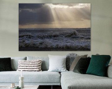 Een meeuw staat op strand met ondergaande zon tijdens een storm van Menno van Duijn