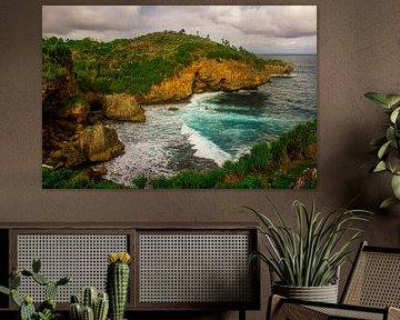 Vue du bord de la colline sur la plage rocheuse verte et la mer ondulée. Vagues s'écrasant sur une p sur kall3bu