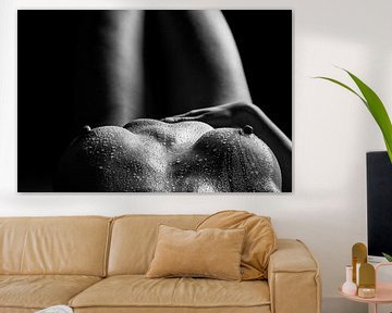 Des gouttes d'eau recouvrent les seins d'une femme nue allongée sur le dos. sur Retinas Fotografie