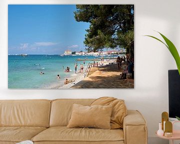Strand met vakantiegangers aan de kust van de historische havenstad Porec aan de Adriatische Zee in 