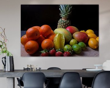 Orangen, Mangos, Papaya, Erdbeere, Ananas, Limetten und Zitronen auf Holzscheibe angeordnet