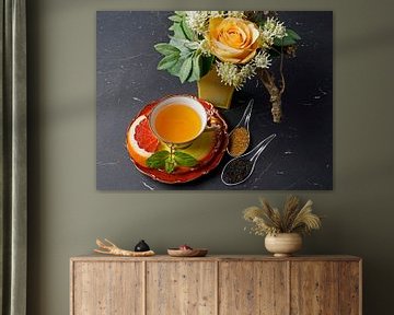 Schwarzer Tee mit Grapefruit in einer Tasse und Löffel mit Rohrzucker