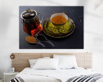 Schwarzer Tee mit Kiwi in einer Tasse, Teekanne, Kiwi in Scheiben