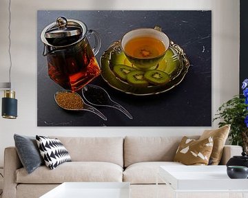 Schwarzer Tee mit Kiwi in einer Tasse, Teekanne, Kiwi in Scheiben