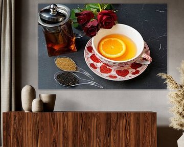 Black tea served with orange slice and red roses by Babetts Bildergalerie