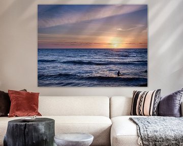 Surfers in the sea during sunset. by Sjoerd van der Hucht