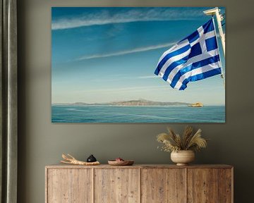 Griechische Flagge fliegt über dem Meer mit einer Insel im Hintergrund von WorldWidePhotoWeb