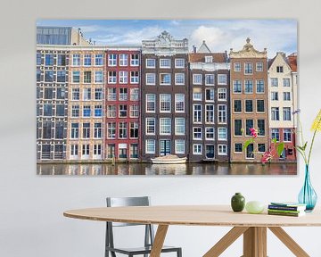 A boat lies in front of the historic canal houses on the Damrak in Amsterdam, the Netherlands by Marc Venema