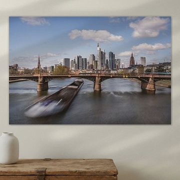 De skyline van Frankfurt met een vrachtschip dat onder de brug van Ignatz Bubis doorvaart, Duitsland van shot.by alexander