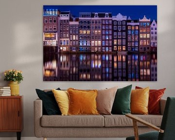 Grachtenhäuser auf dem Damrak in Amsterdam während der blauen Stunde