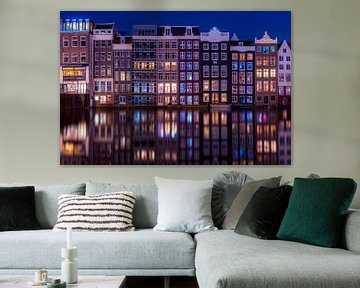 Maisons du canal sur le Damrak à Amsterdam pendant l'heure bleue.