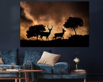 Silhouettes de cerfs nobles sur un paysage de nuages ardents. sur Arjen Heeres