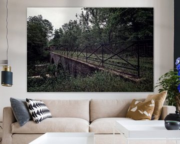 Eine alte Brücke mit einem entfernten Zug am Ende des Gleises von Steven Dijkshoorn